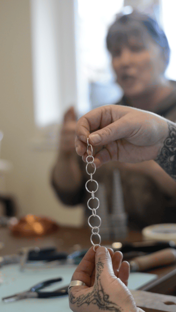 Screenshot 2024-12-03 at 13.55.37 Student holding silver chain during jewellery-making course in Cornwall
