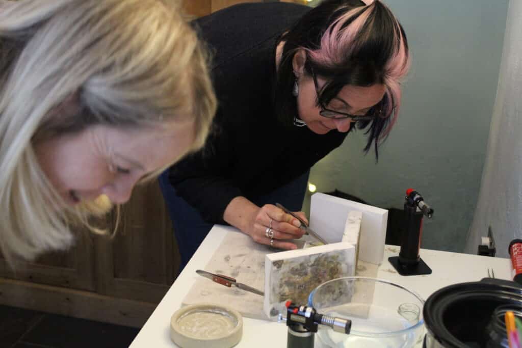 Students making silver jewellery in a hands-on workshop, shaping and soldering metal under expert guidance.