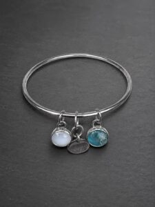 Silver memorial bangle combining birthstones with a pet nose-print charm.