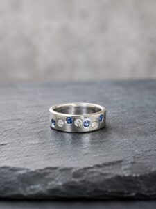 Silver ring with flush-set blue sapphires and diamonds handmade by Cornovii Silver in Cornwall.