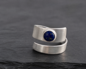 Silver wrap-style memorial ring set with a deep blue glass cabochon.