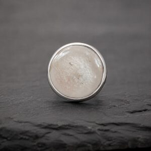 White ashes-in-glass memorial ring showing cremation ashes permanently fused within the glass.